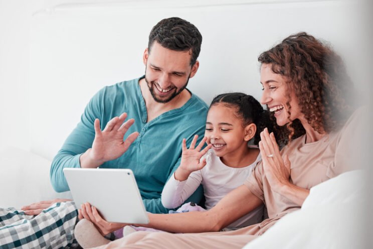 Love, video call and family in bed, smile or conversation online with tablet, bonding or chatting. .